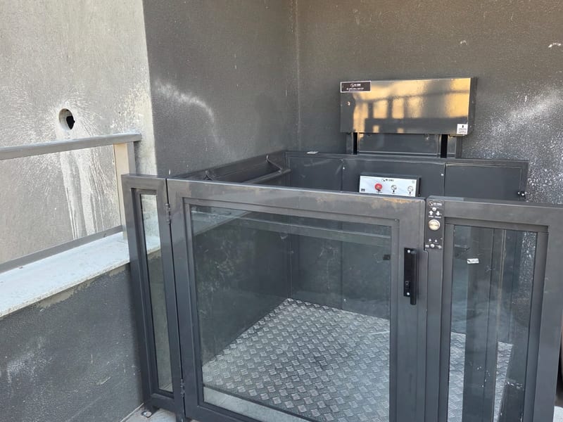 Exemplo de plataforma de acessibilidade com meia cabine e portinhola, equipamento da Máximo Elevadores