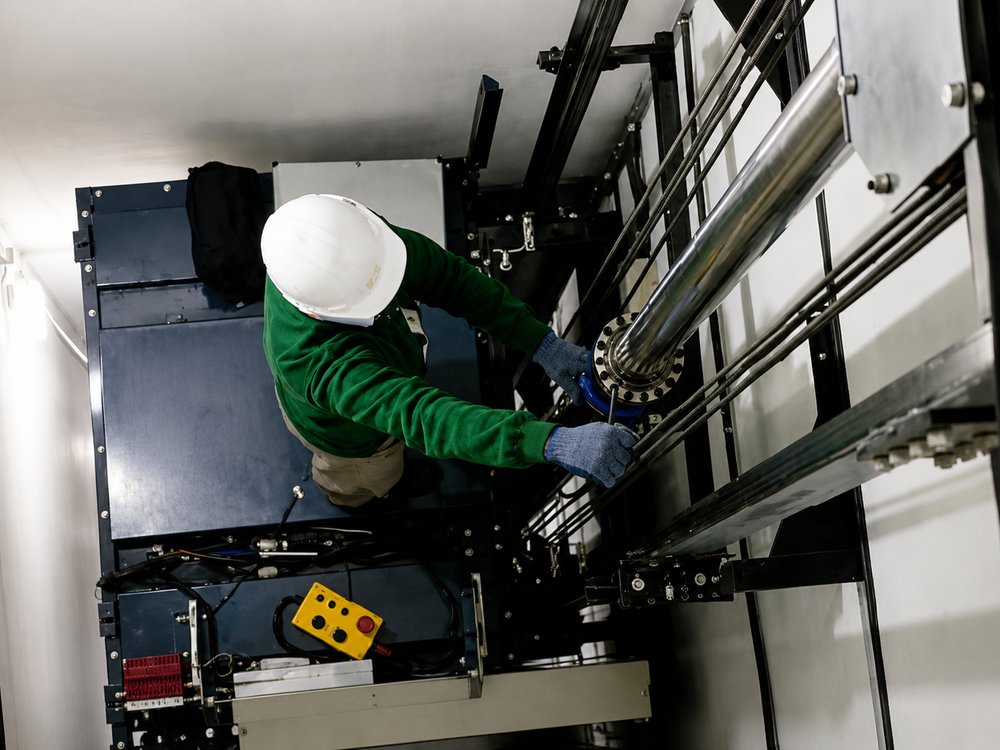 Técnico realizando manutenção em elevador